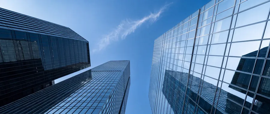Glass towers rising on three sides, looking up