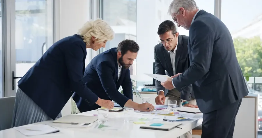 Four colleagues standing over papers