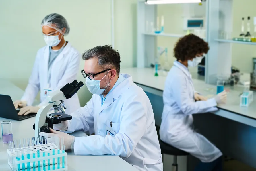 Scientists at microscope bench
