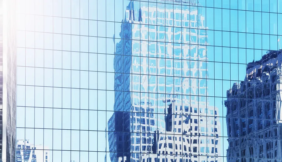 Towers reflected in a glass curtain wall