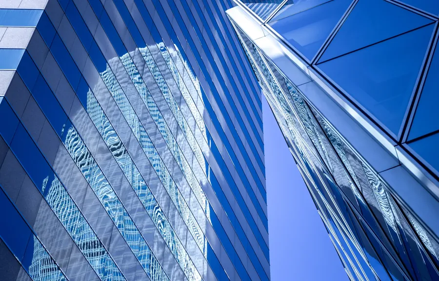 Blue glass facade reflecting a tower