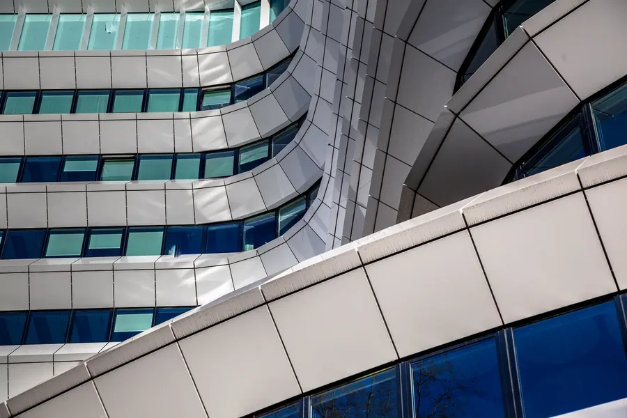 A curved white facade with blue glass bands