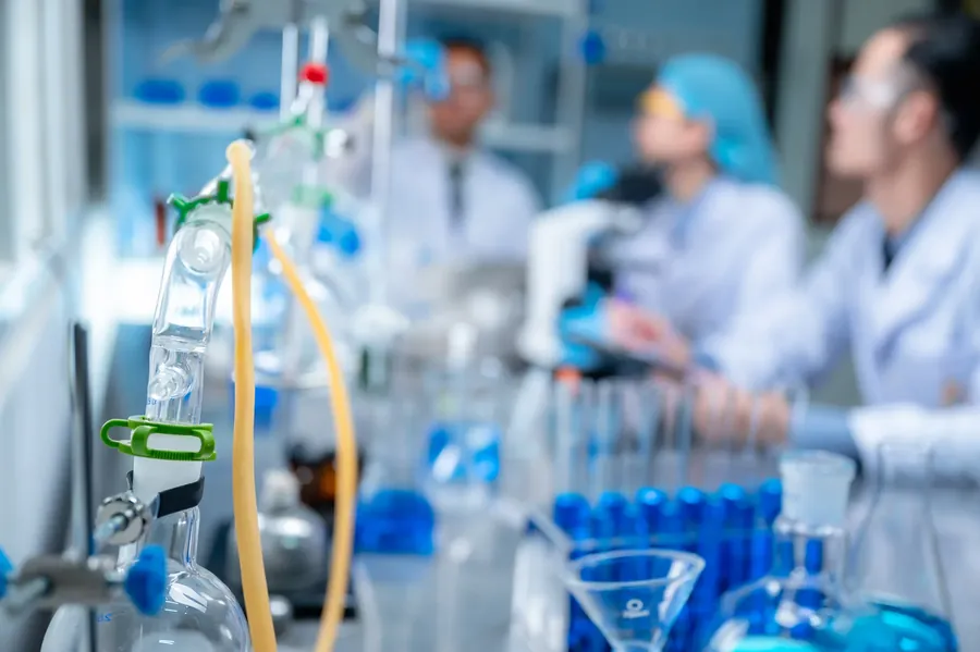 Lab team out of focus behind apparatus