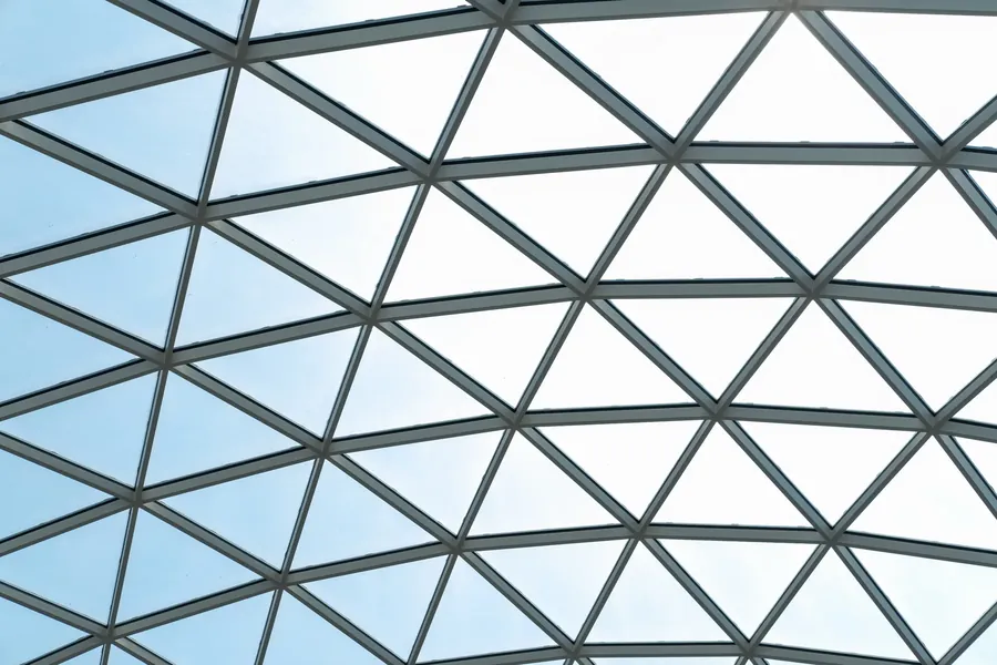 Triangulated glass roof against bright sky