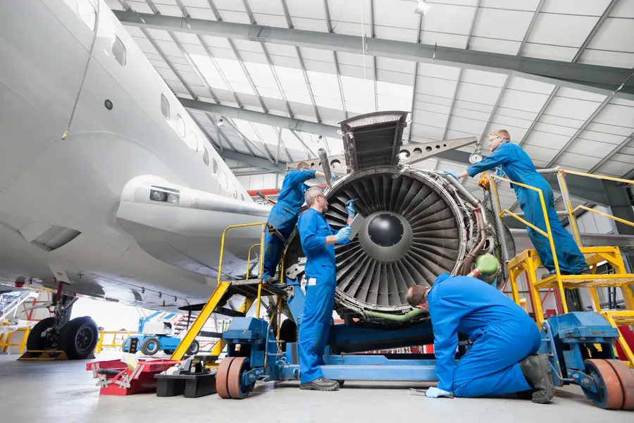 Engineers servicing jet engine