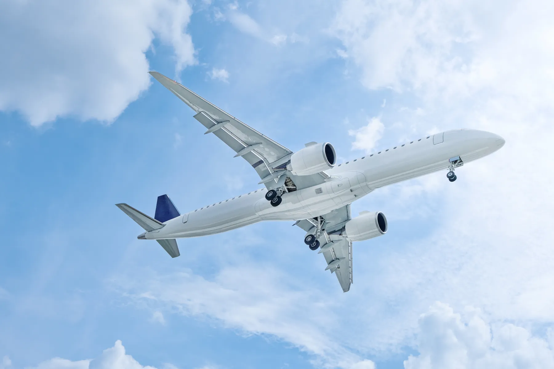 An airliner overhead against a blue sky