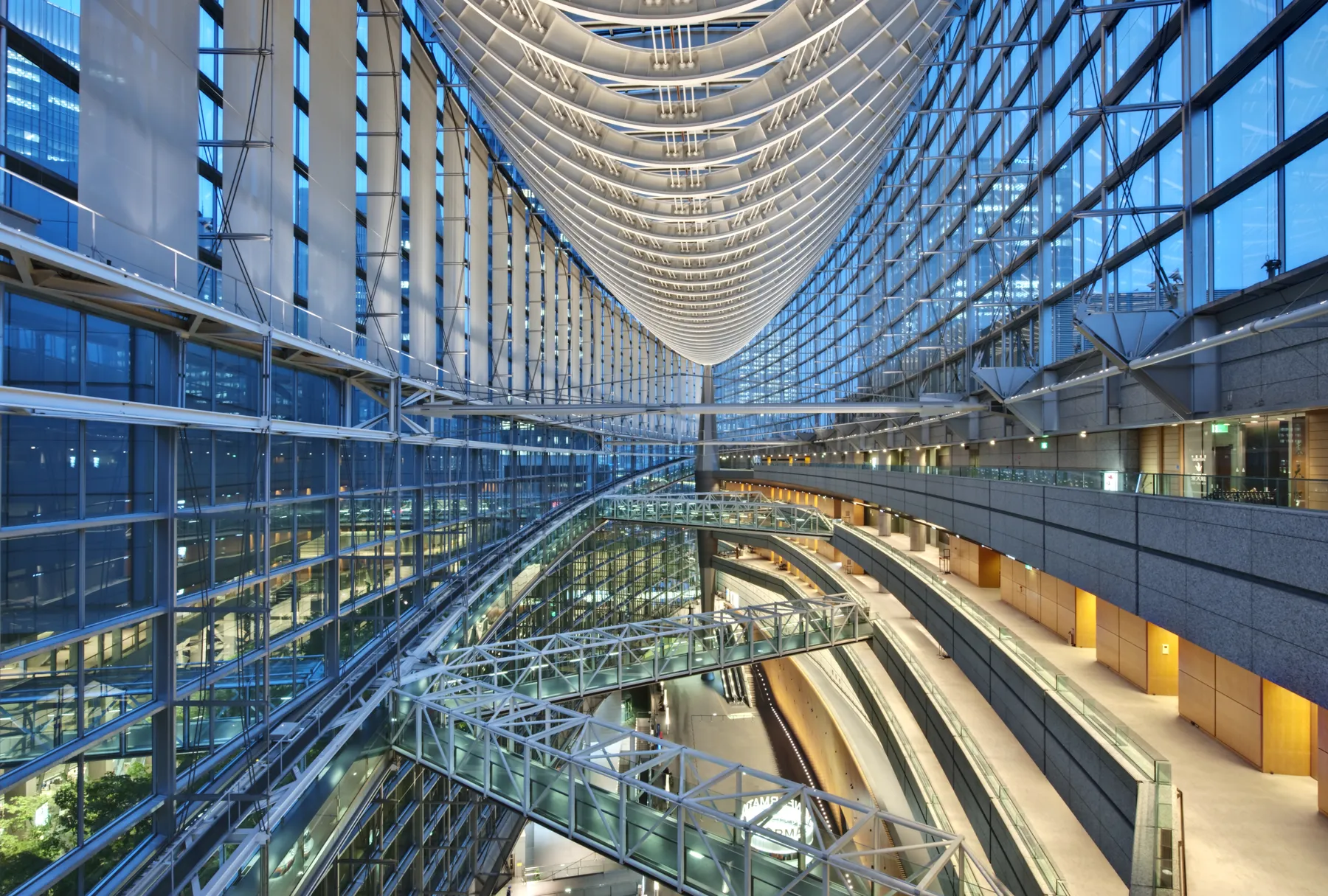 A glass atrium crossed by footbridges